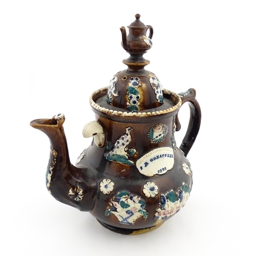 146 - A large 19thC Measham bargeware teapot bearing a plaque for P. R. Greatorex 1891, decorated with fru... 