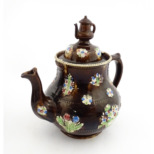 149 - A 19thC Measham bargeware teapot decorated with flowers in baskets and floral motifs. The lid with t... 