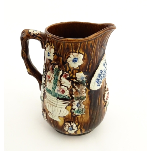 150 - A 19thC Measham bargeware jug with textured bark detail and applied floral and foliate motifs, beari... 