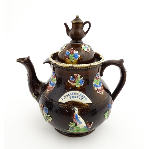 151 - A 19thC Measham bargeware teapot decorated with birds, flowers and foliage, bearing a plaque for 'A ... 