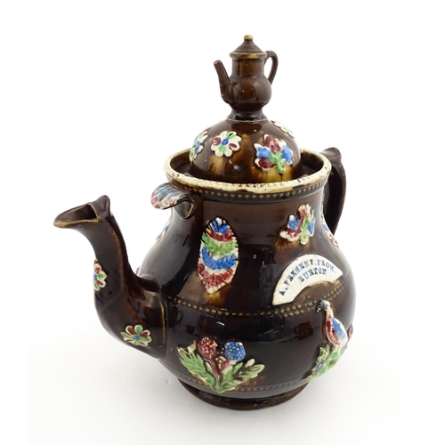 151 - A 19thC Measham bargeware teapot decorated with birds, flowers and foliage, bearing a plaque for 'A ... 