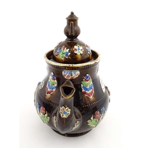 151 - A 19thC Measham bargeware teapot decorated with birds, flowers and foliage, bearing a plaque for 'A ... 