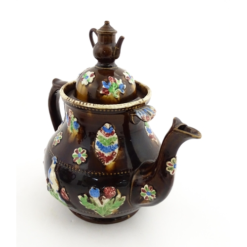 151 - A 19thC Measham bargeware teapot decorated with birds, flowers and foliage, bearing a plaque for 'A ... 