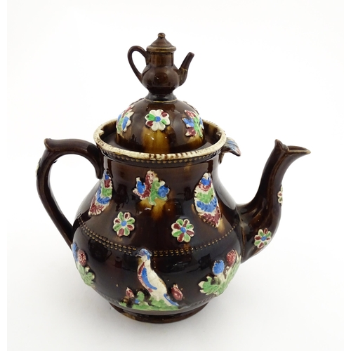 151 - A 19thC Measham bargeware teapot decorated with birds, flowers and foliage, bearing a plaque for 'A ... 