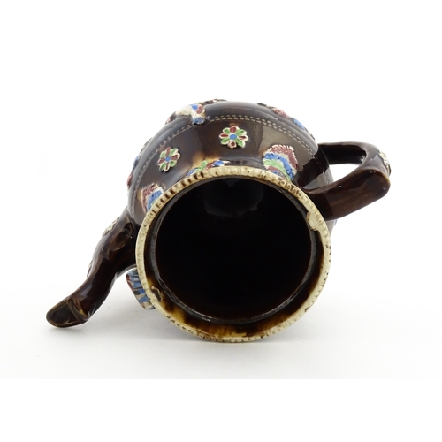 151 - A 19thC Measham bargeware teapot decorated with birds, flowers and foliage, bearing a plaque for 'A ... 