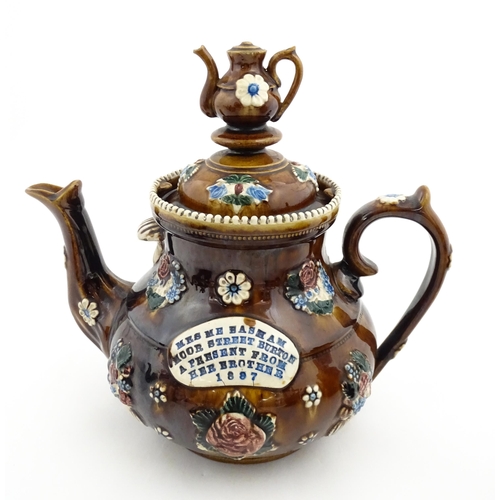 153 - A 19thC Measham bargeware teapot decorated with flowers and foliage, bearing a plaque for 'Mrs ME Ba... 