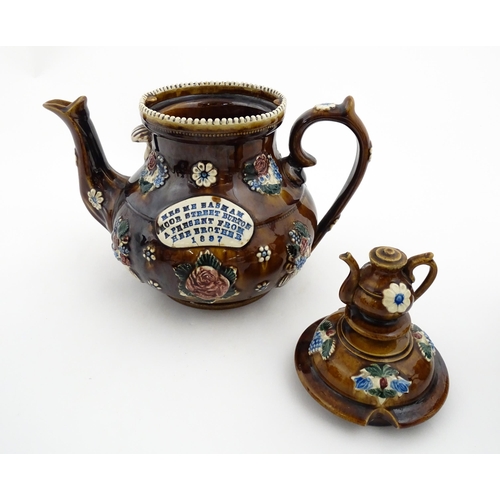 153 - A 19thC Measham bargeware teapot decorated with flowers and foliage, bearing a plaque for 'Mrs ME Ba... 