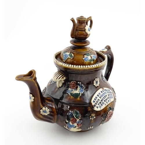 153 - A 19thC Measham bargeware teapot decorated with flowers and foliage, bearing a plaque for 'Mrs ME Ba... 