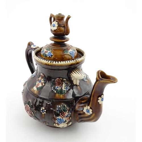 153 - A 19thC Measham bargeware teapot decorated with flowers and foliage, bearing a plaque for 'Mrs ME Ba... 