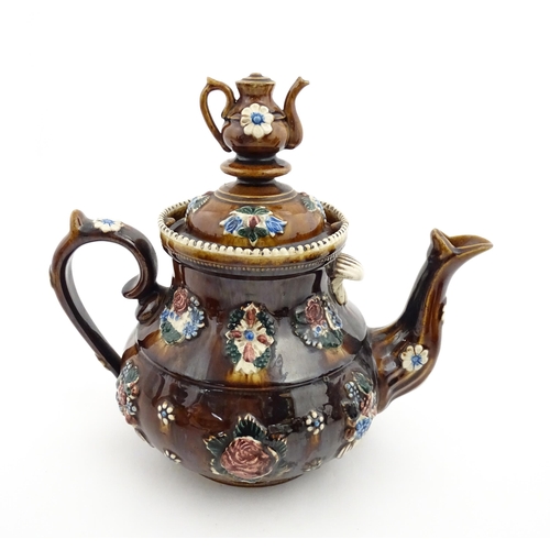 153 - A 19thC Measham bargeware teapot decorated with flowers and foliage, bearing a plaque for 'Mrs ME Ba... 