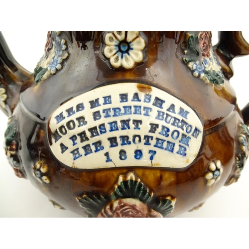 153 - A 19thC Measham bargeware teapot decorated with flowers and foliage, bearing a plaque for 'Mrs ME Ba... 