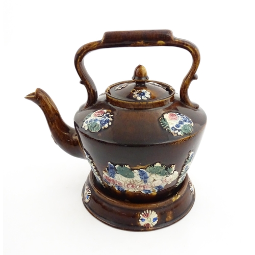 154 - A 19thC Measham bargeware teapot on stand decorated with flowers and foliage. Approx. 9 1/4