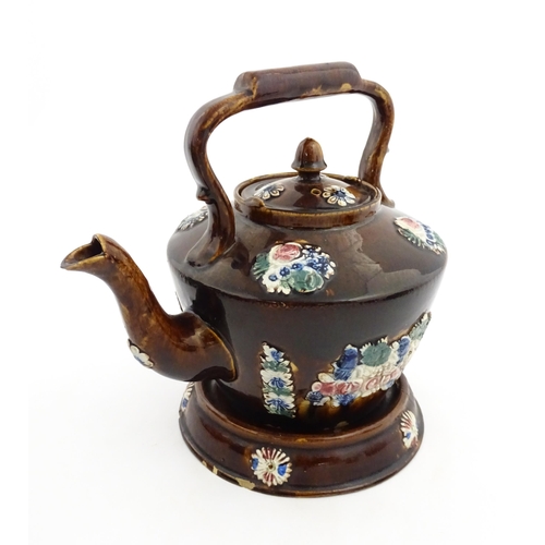 154 - A 19thC Measham bargeware teapot on stand decorated with flowers and foliage. Approx. 9 1/4