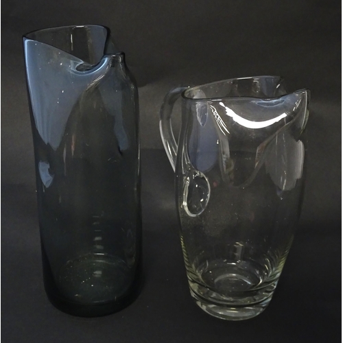 211 - A clear glass lemonade jug together with a mid-century smoke glass dimple jug. Tallest approx 10