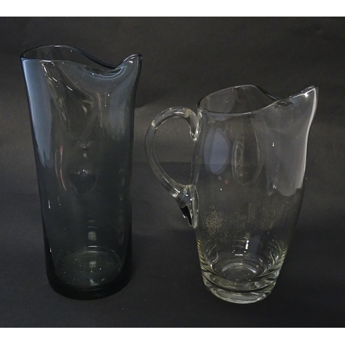 211 - A clear glass lemonade jug together with a mid-century smoke glass dimple jug. Tallest approx 10