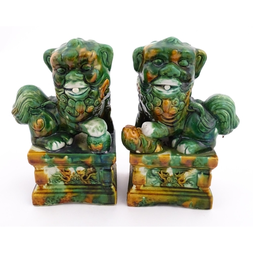 40A - A pair of green and ochre glazed foo dogs / guardian lions. Approx. 8 3/4