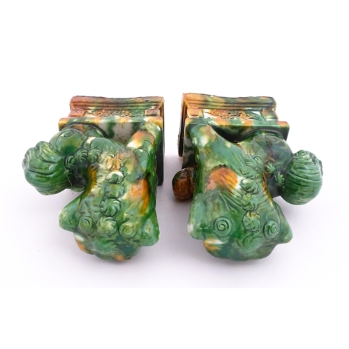 40A - A pair of green and ochre glazed foo dogs / guardian lions. Approx. 8 3/4