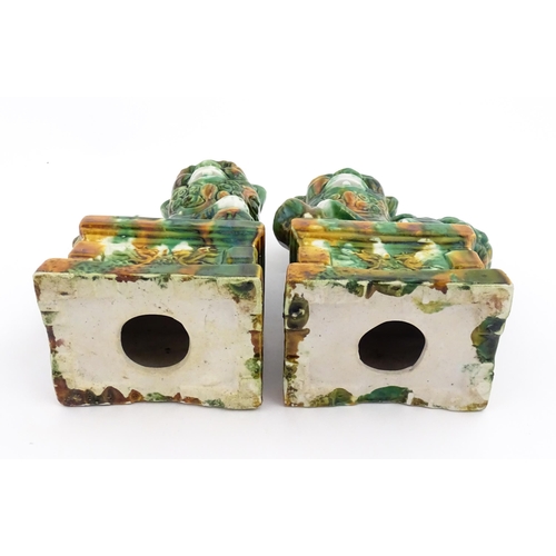 40A - A pair of green and ochre glazed foo dogs / guardian lions. Approx. 8 3/4