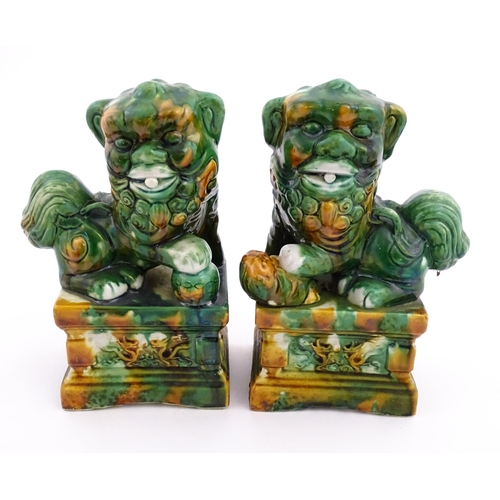 40A - A pair of green and ochre glazed foo dogs / guardian lions. Approx. 8 3/4