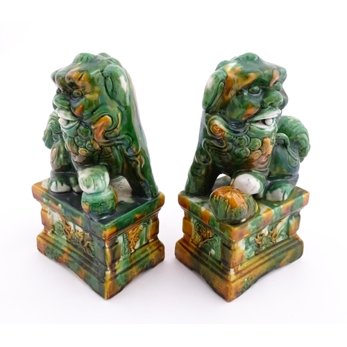 40A - A pair of green and ochre glazed foo dogs / guardian lions. Approx. 8 3/4