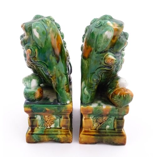 40A - A pair of green and ochre glazed foo dogs / guardian lions. Approx. 8 3/4