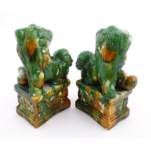 40A - A pair of green and ochre glazed foo dogs / guardian lions. Approx. 8 3/4