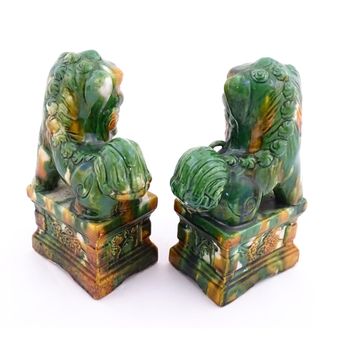 40A - A pair of green and ochre glazed foo dogs / guardian lions. Approx. 8 3/4