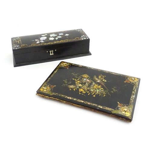 1068 - A Victorian lacquered papier mache desk blotter with hand painted decoration depicting a bird on a r... 