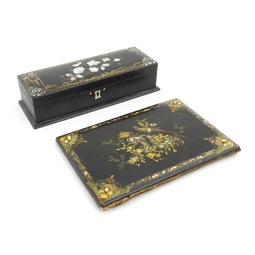 1068 - A Victorian lacquered papier mache desk blotter with hand painted decoration depicting a bird on a r... 