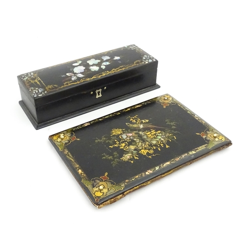 1068 - A Victorian lacquered papier mache desk blotter with hand painted decoration depicting a bird on a r... 