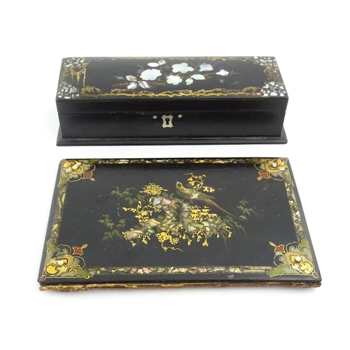 1068 - A Victorian lacquered papier mache desk blotter with hand painted decoration depicting a bird on a r... 