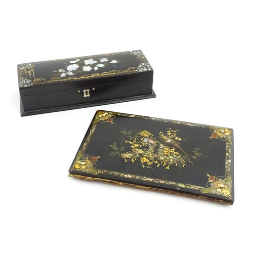 1068 - A Victorian lacquered papier mache desk blotter with hand painted decoration depicting a bird on a r... 