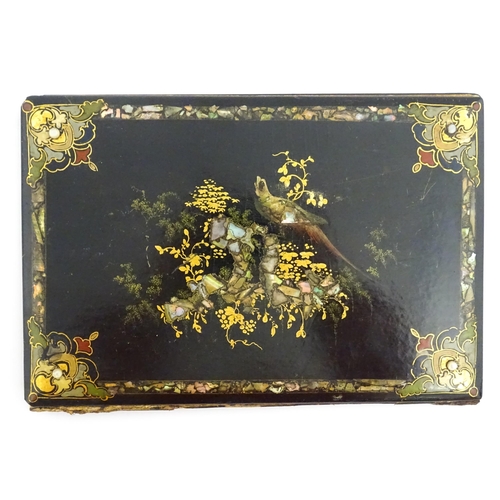 1068 - A Victorian lacquered papier mache desk blotter with hand painted decoration depicting a bird on a r... 