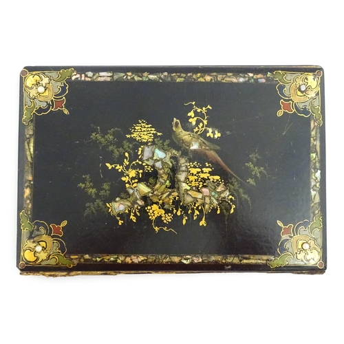 1068 - A Victorian lacquered papier mache desk blotter with hand painted decoration depicting a bird on a r... 