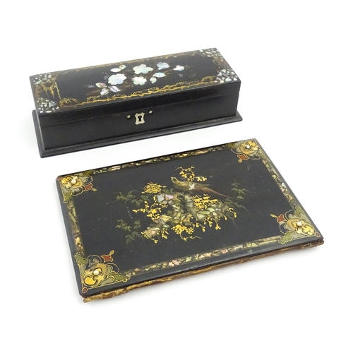 1068 - A Victorian lacquered papier mache desk blotter with hand painted decoration depicting a bird on a r... 