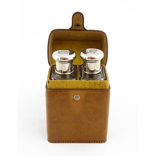 1080 - A cased pair of 20thC glass scent bottles / perfume flasks with glass stoppers and silver plate lids... 