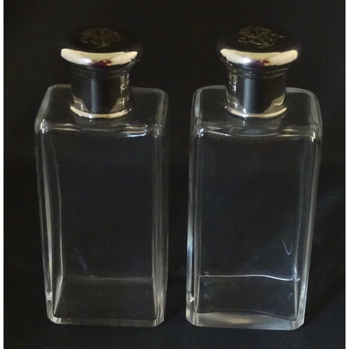 1080 - A cased pair of 20thC glass scent bottles / perfume flasks with glass stoppers and silver plate lids... 