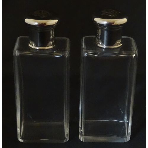 1080 - A cased pair of 20thC glass scent bottles / perfume flasks with glass stoppers and silver plate lids... 