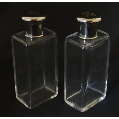 1080 - A cased pair of 20thC glass scent bottles / perfume flasks with glass stoppers and silver plate lids... 