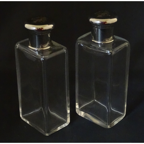 1080 - A cased pair of 20thC glass scent bottles / perfume flasks with glass stoppers and silver plate lids... 