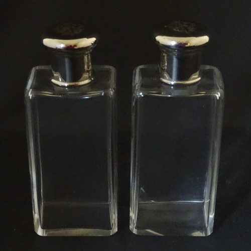 1080 - A cased pair of 20thC glass scent bottles / perfume flasks with glass stoppers and silver plate lids... 