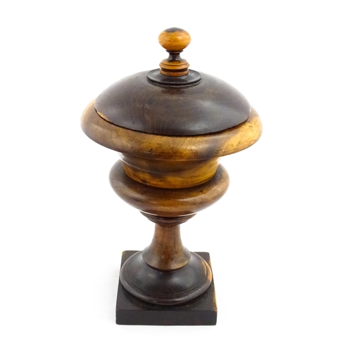 1100 - Treen : A wooden pedestal pot and cover raised on a squared base. Approx. 10