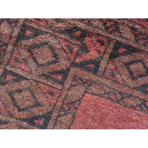 1313 - Carpet / Rug : A red ground rug with four central medallions decorated with geometric and foliate de... 