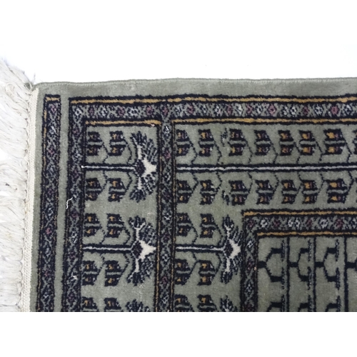 1315 - Carpet / Rug: A grey ground rug decorated with repeating geometric motifs. Approx. 65