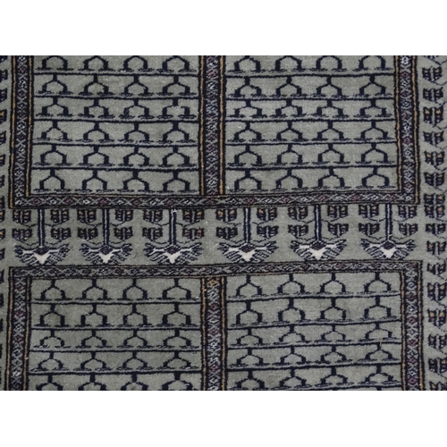 1315 - Carpet / Rug: A grey ground rug decorated with repeating geometric motifs. Approx. 65