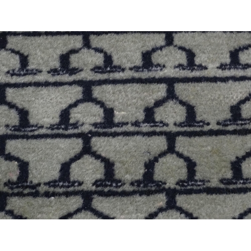 1315 - Carpet / Rug: A grey ground rug decorated with repeating geometric motifs. Approx. 65