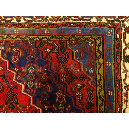 1316 - Carpet / Rug : A North West Persian Hamadan carpet the red ground decorated with cream vignette with... 