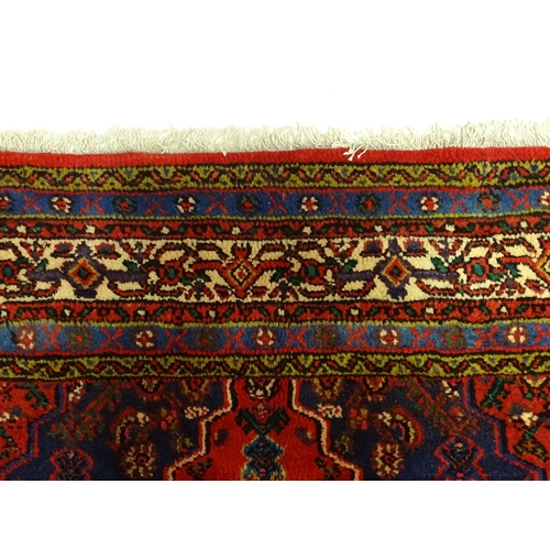 1316 - Carpet / Rug : A North West Persian Hamadan carpet the red ground decorated with cream vignette with... 