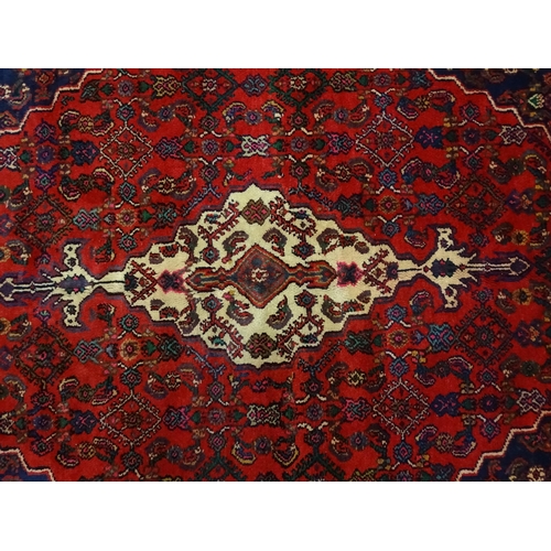 1316 - Carpet / Rug : A North West Persian Hamadan carpet the red ground decorated with cream vignette with... 