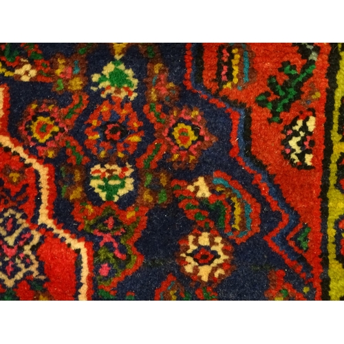 1316 - Carpet / Rug : A North West Persian Hamadan carpet the red ground decorated with cream vignette with... 